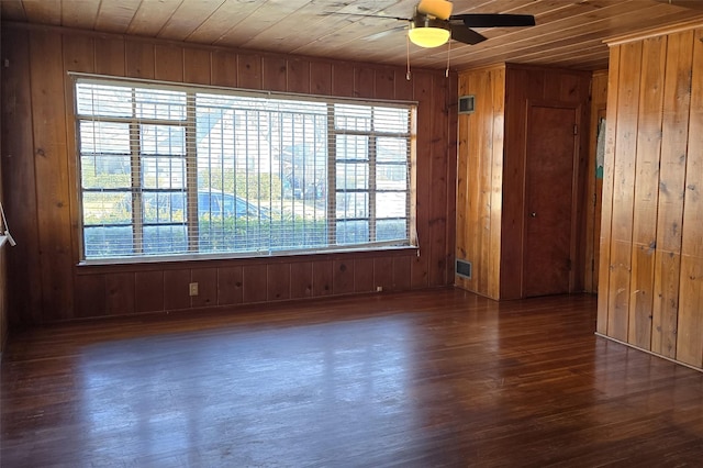 empty room with wood walls, ceiling fan, wood ceiling, and dark hardwood / wood-style floors