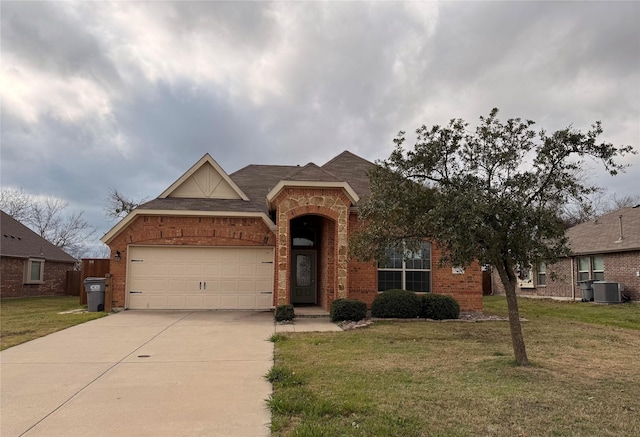 view of front of property with brick siding, an attached garage, a front yard, cooling unit, and driveway