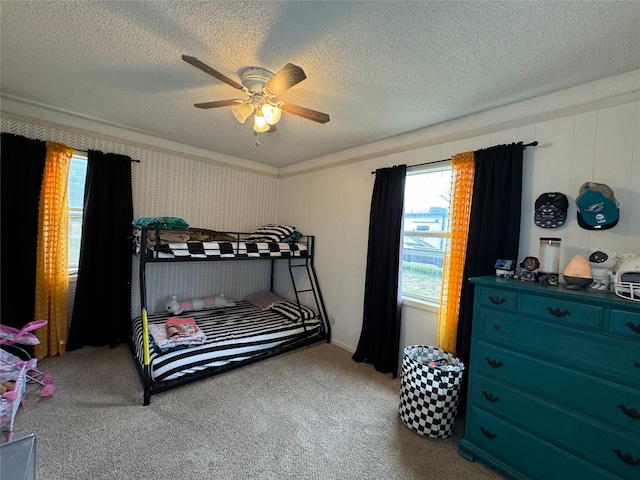 bedroom featuring crown molding, ceiling fan, carpet floors, and a textured ceiling