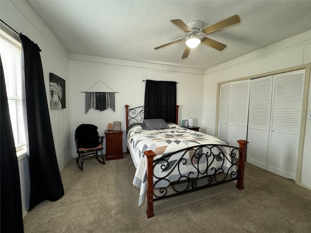 bedroom with ceiling fan, carpet, a closet, and a textured ceiling