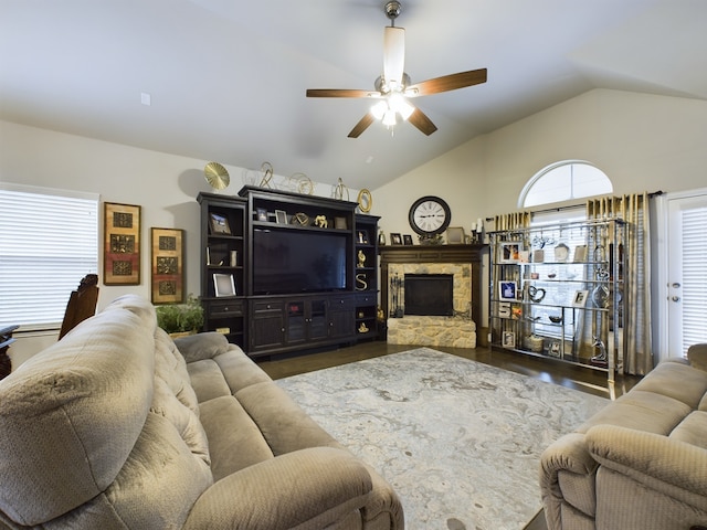 living room with ceiling fan, a stone fireplace, dark hardwood / wood-style flooring, and lofted ceiling