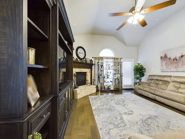 living room with ceiling fan, dark wood-type flooring, lofted ceiling, and a fireplace