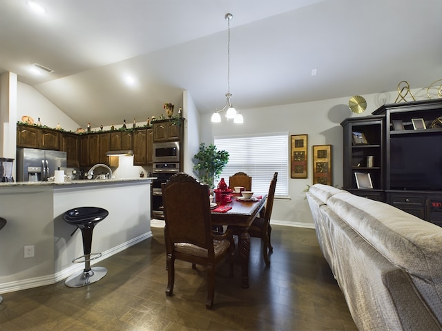 dining area with sink, dark hardwood / wood-style floors, vaulted ceiling, and a notable chandelier