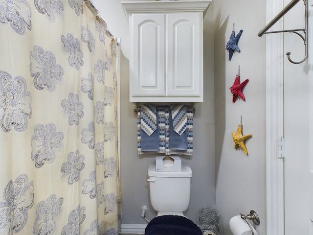 bathroom featuring toilet and a shower with shower curtain