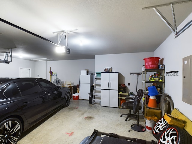 garage featuring a garage door opener, white refrigerator, and electric panel