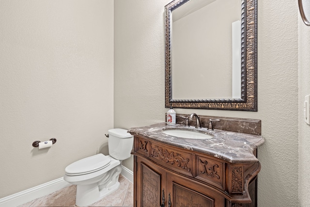 bathroom with tile patterned flooring, vanity, and toilet