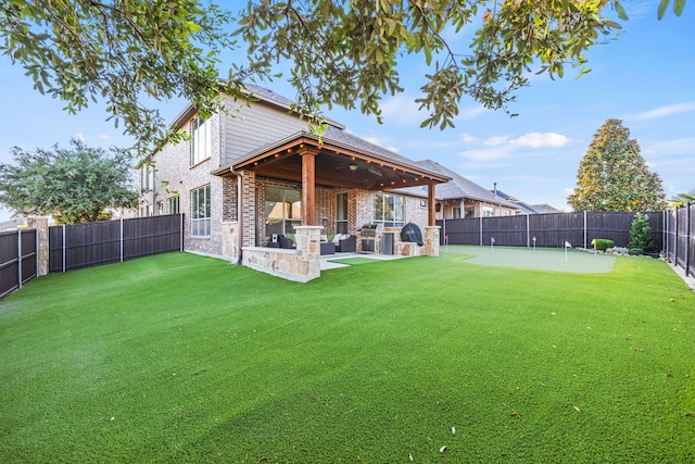 back of house featuring a lawn and area for grilling