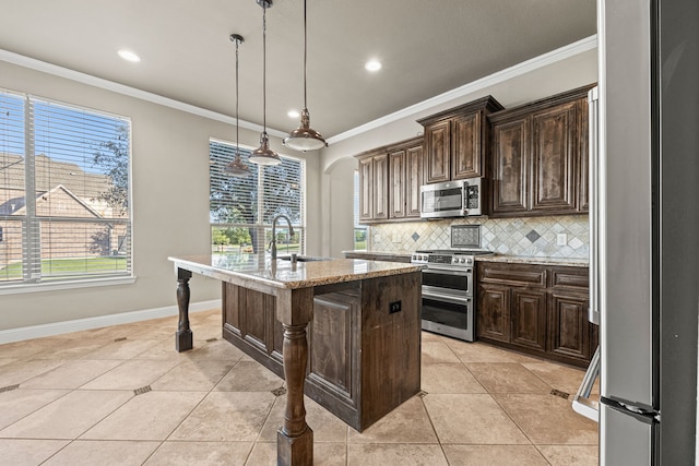 kitchen featuring decorative backsplash, stainless steel appliances, pendant lighting, a center island with sink, and a breakfast bar area