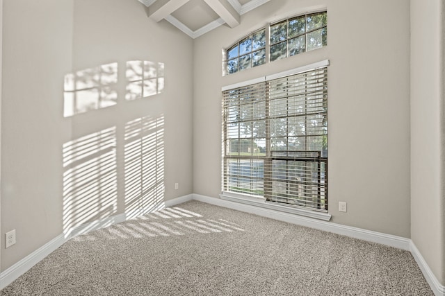 carpeted empty room with beam ceiling and coffered ceiling