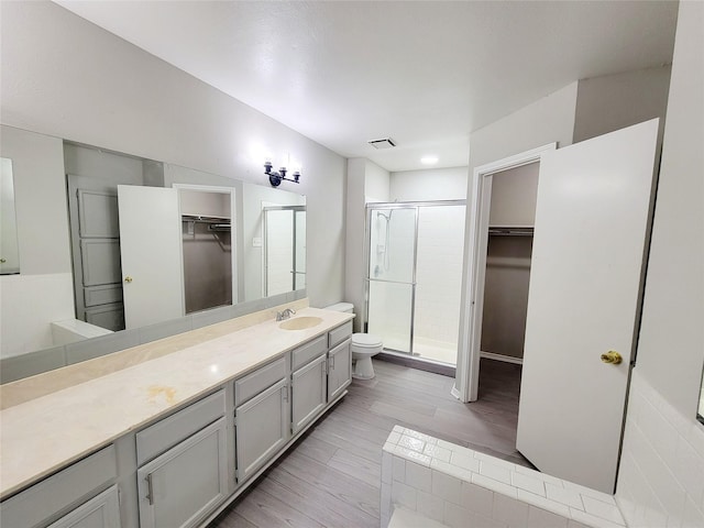 bathroom with vanity, toilet, and a shower with shower door