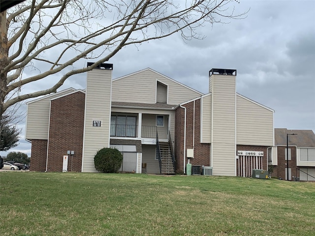 rear view of property with a lawn and central AC unit