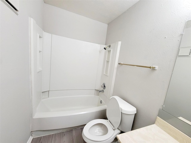 bathroom with hardwood / wood-style floors, toilet, and washtub / shower combination