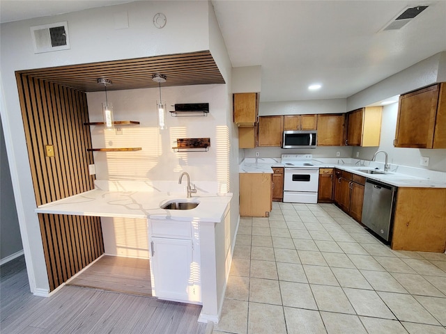 kitchen featuring decorative light fixtures, light tile patterned floors, sink, and appliances with stainless steel finishes