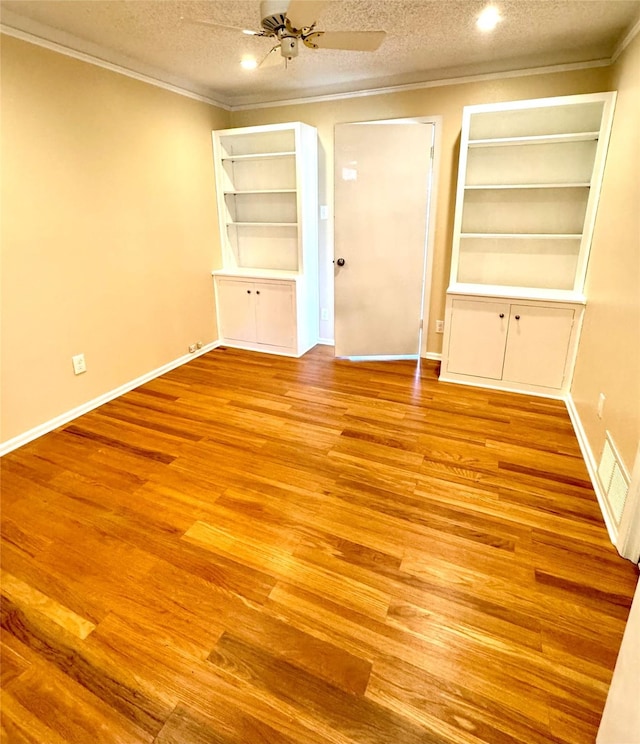 empty room with ceiling fan, crown molding, a textured ceiling, and light wood-type flooring