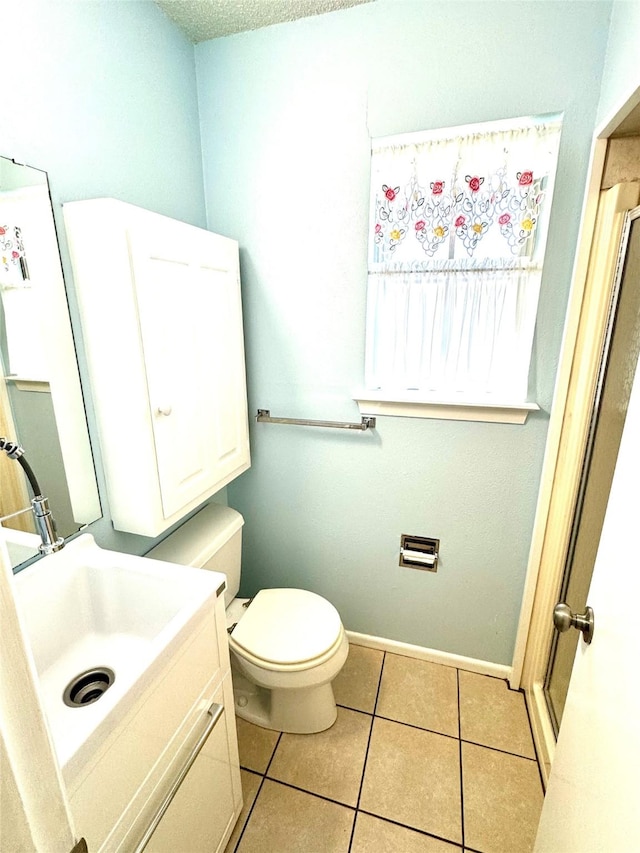 bathroom with tile patterned flooring, vanity, and toilet