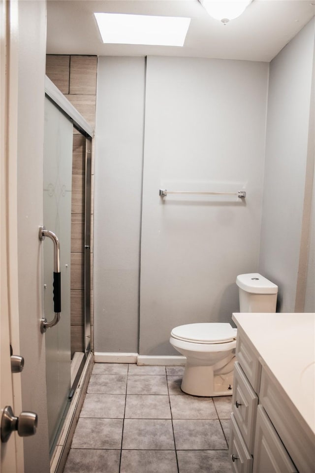 bathroom featuring vanity, a shower with shower door, tile patterned floors, and toilet