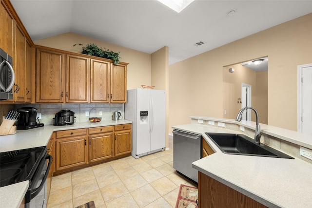 kitchen with dishwasher, white refrigerator with ice dispenser, backsplash, sink, and vaulted ceiling