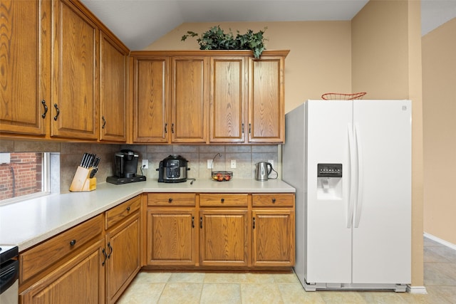 kitchen with white refrigerator with ice dispenser, decorative backsplash, and lofted ceiling