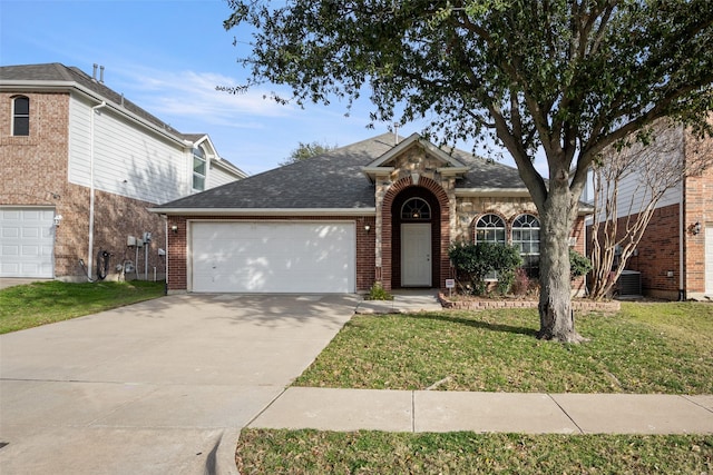 view of front of home featuring a front lawn, central AC unit, and a garage