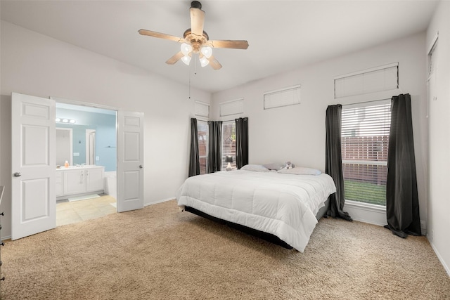 carpeted bedroom featuring ceiling fan and ensuite bath