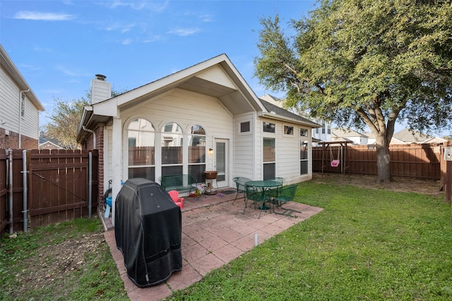 back of house featuring a lawn and a patio area