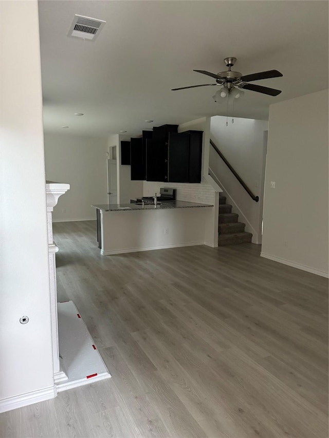 unfurnished living room featuring ceiling fan and dark hardwood / wood-style floors