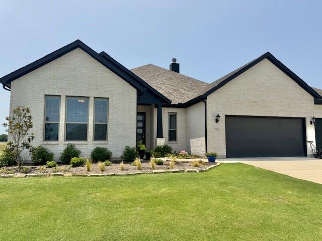 1700 Flint Cir, Van Alstyne, TX 75495 - view of front of home featuring brick siding, a garage, and a front lawn