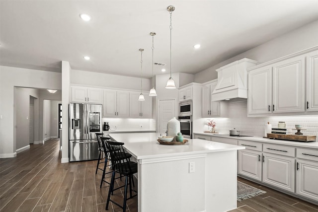 kitchen featuring stainless steel appliances, a center island, and white cabinets