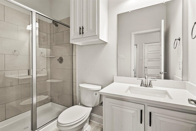 bathroom with vanity, a shower with shower door, and toilet