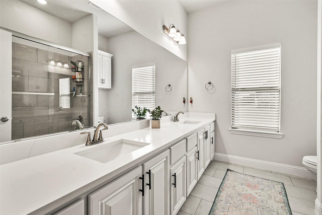 bathroom with vanity, toilet, tile patterned flooring, and a shower with door