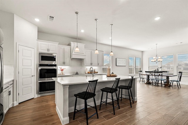 kitchen with white cabinets, a large island, pendant lighting, and custom exhaust hood