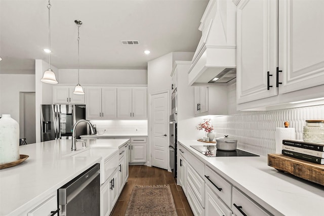 kitchen featuring premium range hood, appliances with stainless steel finishes, pendant lighting, and white cabinets