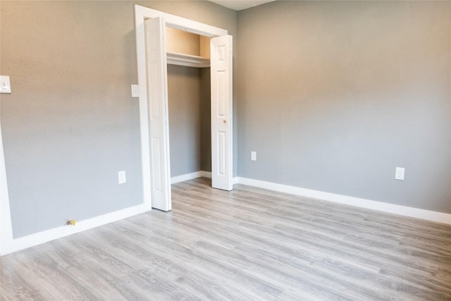 unfurnished bedroom featuring a closet and light wood-type flooring