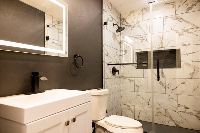 bathroom with a shower with door, vanity, and toilet