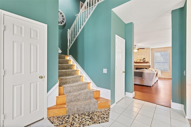 stairway featuring ceiling fan and tile patterned flooring