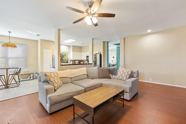 living room featuring ceiling fan and light hardwood / wood-style flooring