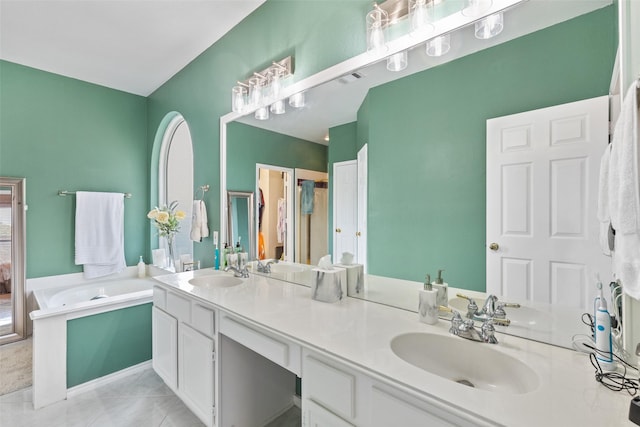 bathroom with tile patterned flooring, vanity, and a tub