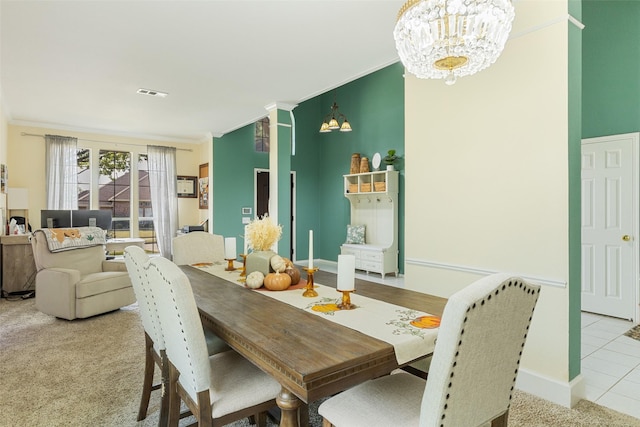 dining area with light colored carpet and an inviting chandelier