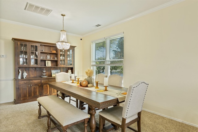 carpeted dining area with an inviting chandelier and ornamental molding