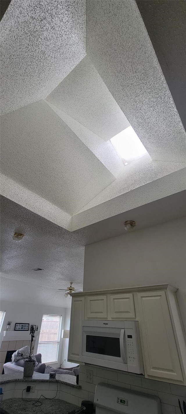 kitchen featuring white cabinets and ceiling fan