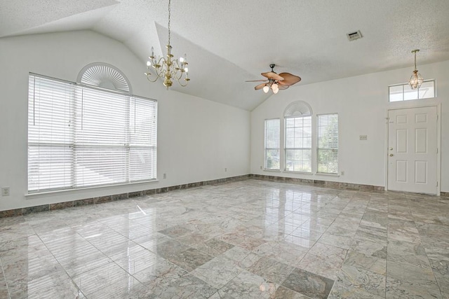 interior space featuring vaulted ceiling, a wealth of natural light, and ceiling fan with notable chandelier