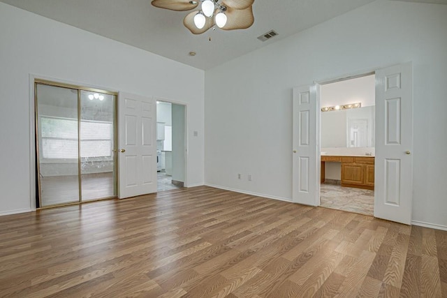 unfurnished bedroom with connected bathroom, ceiling fan, a closet, and light wood-type flooring