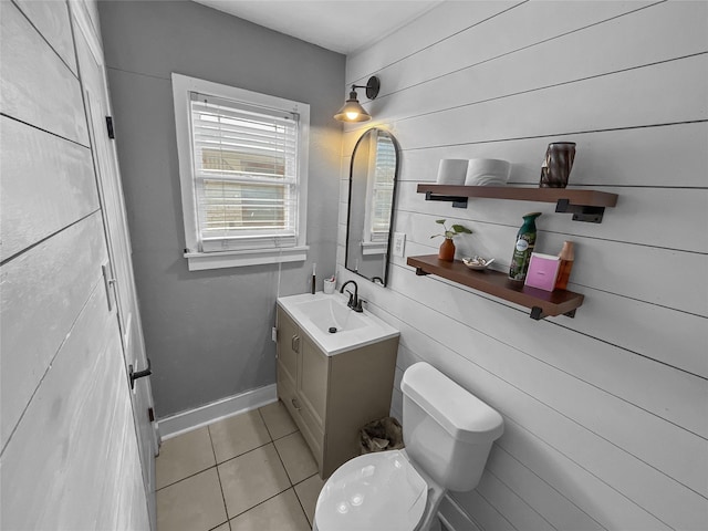 bathroom with tile patterned floors, wood walls, vanity, and toilet