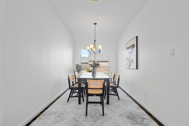 dining room featuring hardwood / wood-style floors, a chandelier, and lofted ceiling