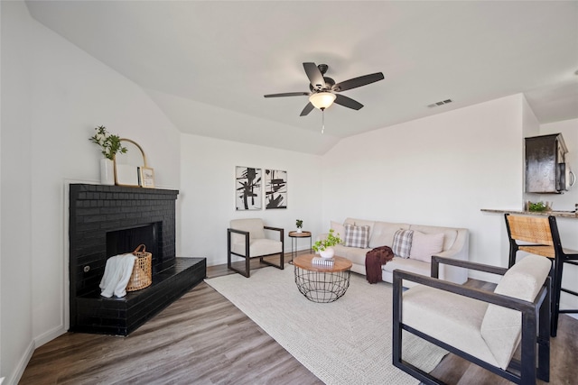 living room featuring ceiling fan, a fireplace, lofted ceiling, and hardwood / wood-style flooring