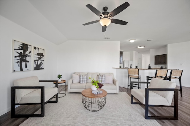 living room with ceiling fan, light hardwood / wood-style flooring, and vaulted ceiling