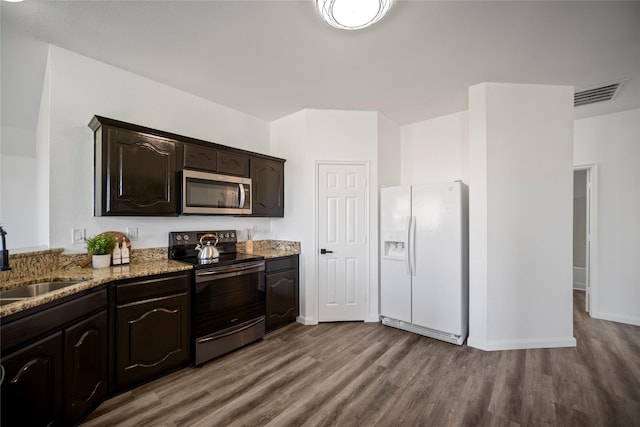 kitchen featuring wood-type flooring, dark brown cabinetry, stainless steel appliances, and sink