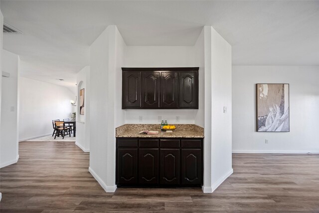 kitchen featuring wood-type flooring and dark brown cabinetry