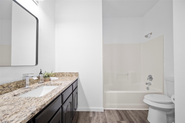 full bathroom featuring hardwood / wood-style floors, vanity, toilet, and washtub / shower combination