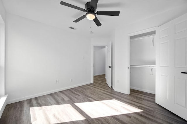 unfurnished bedroom with ceiling fan, a closet, and hardwood / wood-style flooring